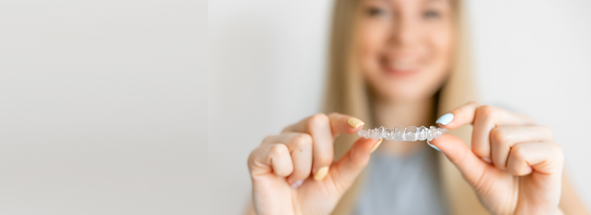 A person holding up a small object with both hands against a white background.