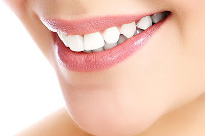The image features a close-up view of a person s face with a focus on their teeth, which are straightened and appear bright white, suggesting a dental care product or service being advertised.