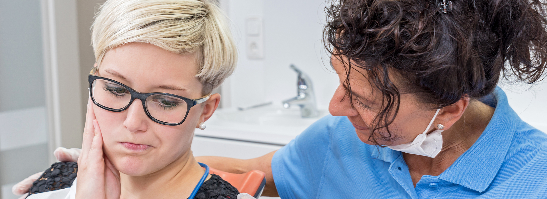 Woman receiving dental care from female dentist.