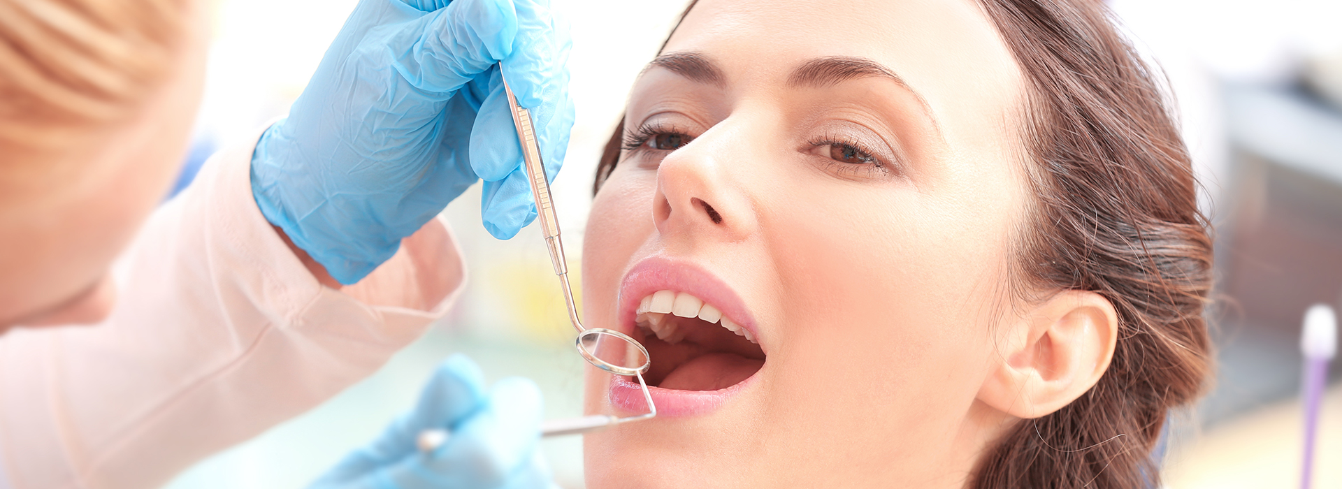 A person receiving dental care with a dentist performing a procedure on their teeth.