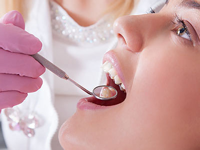 A dental professional performing oral care on a patient s teeth.