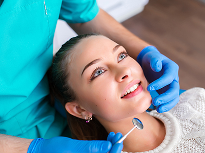 A dental professional performing a cosmetic procedure on a patient in an office setting.